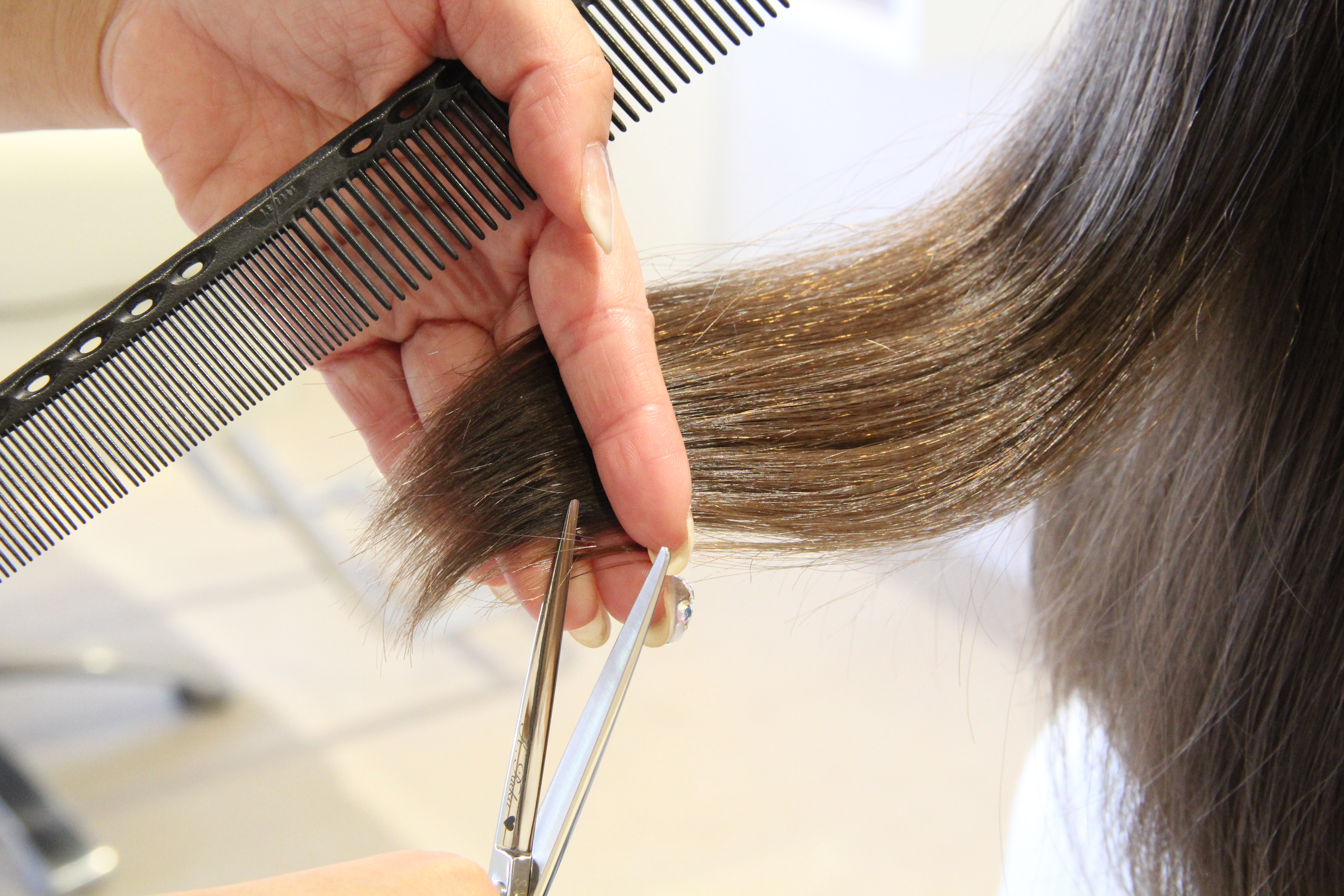 TEAM hairのスタイリストが酸性ストレート専用の薬剤で丁寧に毛先をカットする様子